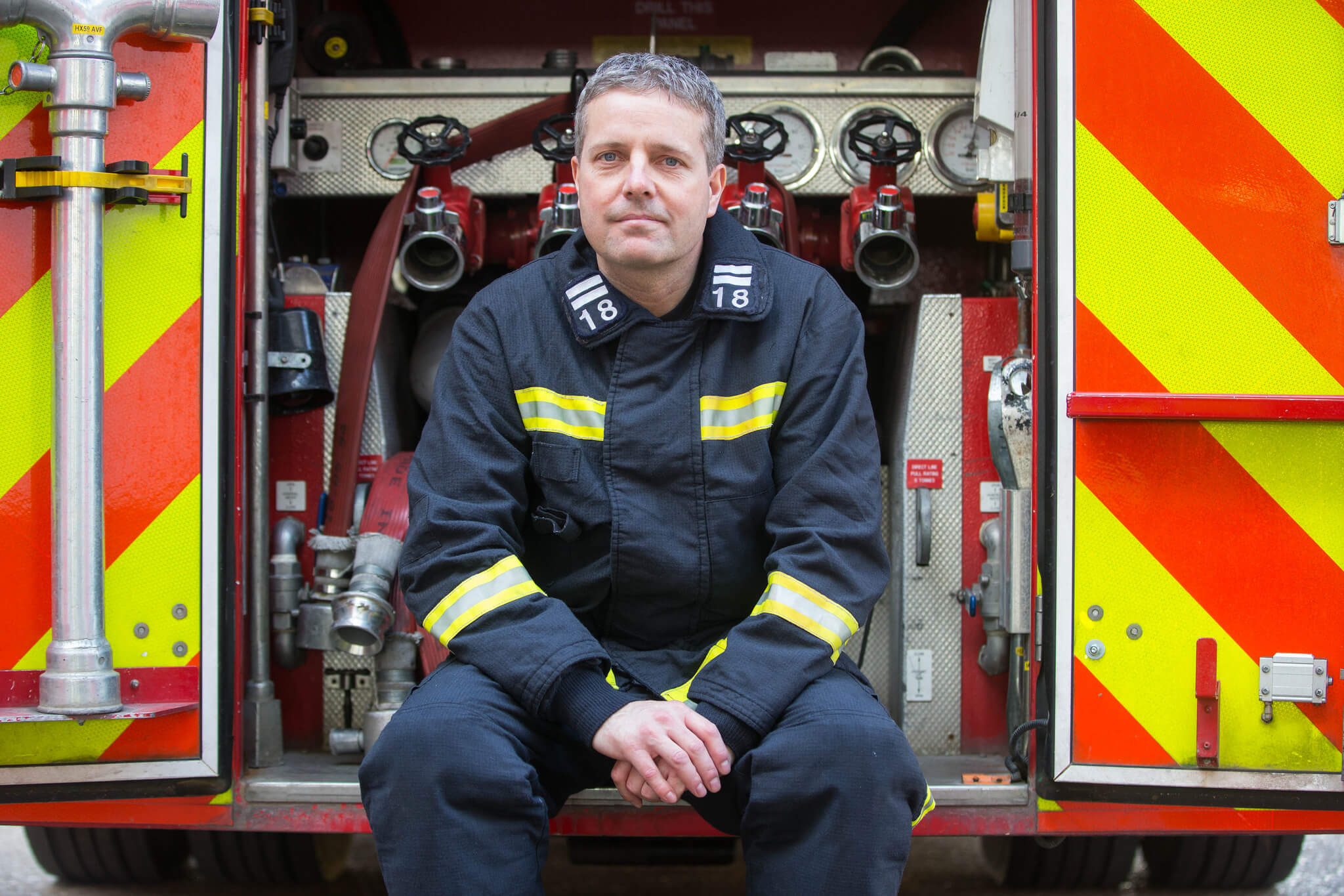 Firefighter sitting in back of fire engine